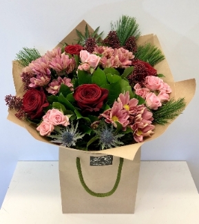 This bouquet is stylish with tones of red and pink. Including roses, berries and thistle. 