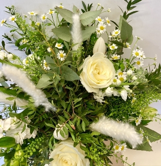 Natural hand tied bouquet in white tones including roses, stocks and pampas grass. 
