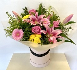 Bright and refreshing bouquet with chrysanthemums, lilies, roses, solidago, germini, and stocks, complemented by eucalyptus and wrapped in luxury cellophane with a hatbox presentation.