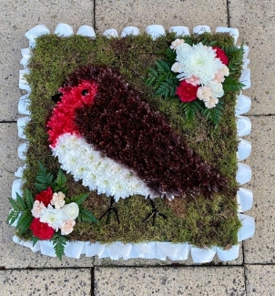 Beautifully designed red robin funeral tribute with moss background and spray paint detailing. 