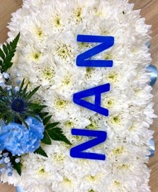 Heart-shaped funeral tribute with laminated wording, white chrysanthemums, delicate ribbon edge, and matching focal. Customizable colour options available.