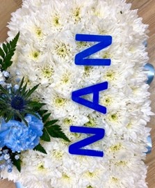 Heart funeral tribute with light blue ribbon and focal with NAN wording laminated on the front. 