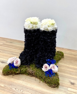 Wellington Boot funeral tribute on a moss base with black and white wellington boots
