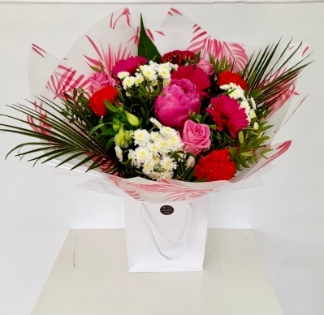 Stunning seasonal bouquet including peony, roses, germini and palms in pink and white tones. 
