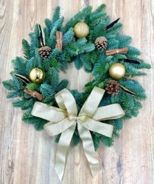 Modern fresh spruce wreath adorned with gold baubles, black feathers, cinnamon, pine cones and finished with a chunky gold bow. 