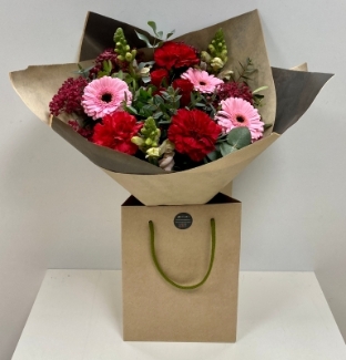 Stunning new bouquet with rich red and baby pink florals including roses, gypsophila and germini wrapped in craft paper hand tied in water. 
