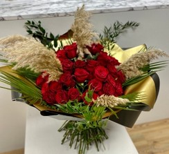 The ultimate gift of 50 Luxury red roses, adorned with pampas grass and high end foliage, wrapped in gold metallic cellophane, hand tied in water. 