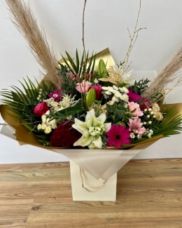 Beautiful bouquet filled with crisp white and rose-pink tones including roses, germini and hypericum berries all brought together with gold painted branches and fluffy pampas grass. 