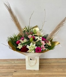 Beautiful bouquet filled with crisp white and rose-pink tones including roses, germini and hypericum berries all brought together with gold painted branches and fluffy pampas grass. 