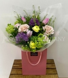 A bouquet in tranquil tones including roses, allium, tulips, viburnum and more. Presented in our signature gift bag, hand tied in water. 