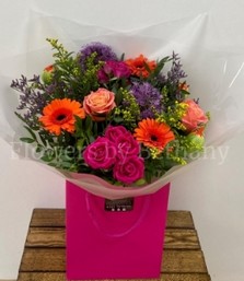 Spring bouquet filled with citrus toned florals including rose, spray rose, germini and solidago. Hand tied in water and presented in our signature bag and cellophane wrap. 