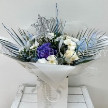 Stunning frozen themed bouquet filled with fresh florals. Design includes blue thistle, white germini, white rose, blue delphinium, blue hydrangea, white gypsophila, white carnations, palm leaves and finished with a removable silver star wand.