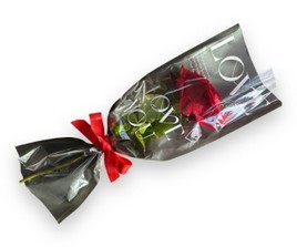 A single red rose elegantly cradled in a paper wrap adorned with heartfelt words of love.