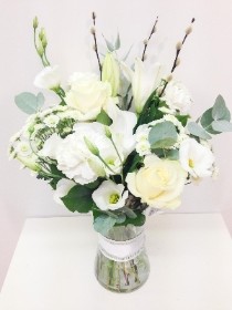 Hand tied in a vase with white lily, white roses and willow with eucalyptus. 