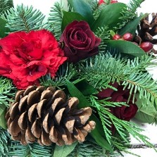 Festive table arrangement with warm red tones and candle. 