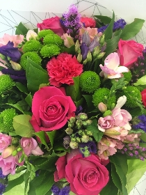 Hand tied bouquet in pinks and purples including roses, alstroemeria and statice. 