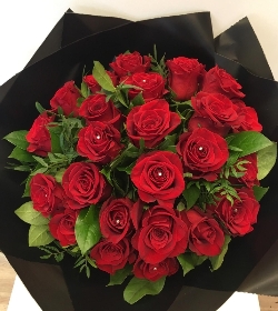 Luxury 24 red rose bouquet, finished with complimentary foliage and wrapped in our signature black cellophane and bag. 