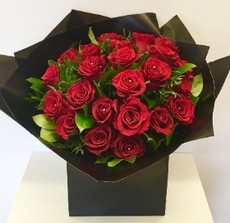 Luxury 24 red rose bouquet, finished with complimentary foliage and wrapped in our signature black cellophane and bag. 