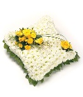Classic massed cushion funeral tribute created using chrysanthemums and other seasonal flowers. 