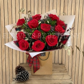 Luxury red rose Christmas bouquet with winter foliage and tartan festive accents.