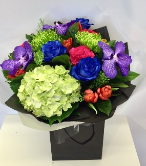 Extraordinary hand tied including blue roses, purple vander orchids and a mix of traditional vibrant flowers. 