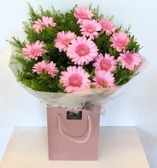 Hand tied bouquet made of pink germini, and green bell foliage. 