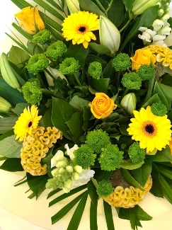 Hand tied in fresh lemon and green tones,including lily, roses, snapdragons, celosia and chrysanthemums. 
