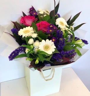 Hand tied of pink, purples and whites. Including roses, germini, carnation and alstroemeria. 