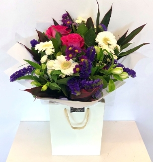 Hand tied of pink, purples and whites. Including roses, germini, carnation and alstroemeria. 