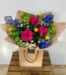 Make someone's day with this groovy bunch filled with roses, delphinium, craspedia, matricaria & more! 