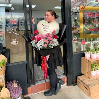 Large Valentine’s bouquet with red roses, pink flowers, gypsophila and eucalyptus in black wrap with red ribbon, created out of water to place into your own vase, featuring a personalised heart-shaped balloon arranged within the bouquet.