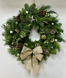 Fresh foliage door wreath filled with lime slices, pine cones and berries finished with a hessian bow.