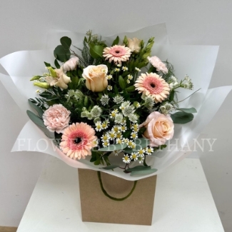 A bouquet filled with peach toned florals and foliage. Design includes roses, germini, carnations, lisianthus and a mix of other seasonal varieties. 