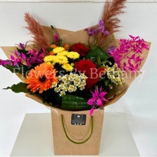 A beautiful bouquet of fresh florals in retro rainbow colours including orange germini, yellow chrysanthemum, purple clematis, orange pampas grass, pink dried ruscus, matricaria daisy and red roses. All wrapped in our kraft paper and matching bag. 