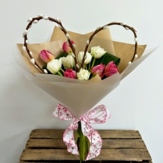 Pink and white tulip bouquet with a handcrafted pussy-willow heart, wrapped in luxury paper and tied with a patterned ribbon.