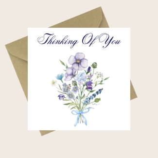 Thinking Of You card with a delicate blue and purple floral bouquet and ribbon.