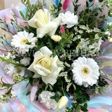 All white bouquet with a whimsical twist, pastel bunny tails dispersed through the bouquet. Wrapped in a wavy print bag and cellophane hand tied in water. 