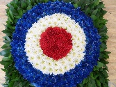MOD Funeral tribute made with blue, white and red chrysanthemum and foliage background. 