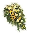 Country-style single-ended spray with seasonal yellow flowers and greenery.