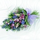 Tied flat spray with pink and purple seasonal flowers.