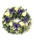 Loose wreath funeral tribute in electric purple and white tones. 