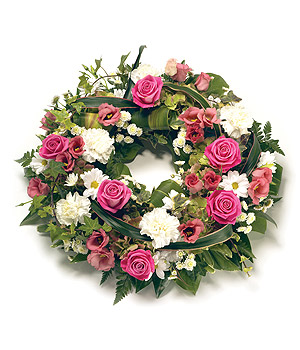 Loose funeral wreath with pink and white florals, accented with complementary foliage.